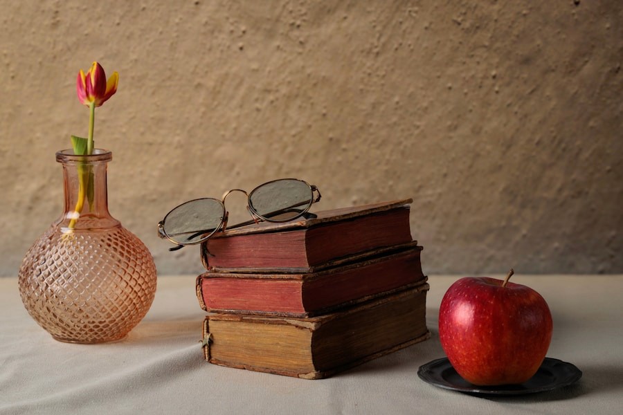 Premium-Stillleben mit Büchern, Brille und Apfel in kühlem Licht